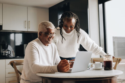 couple in kitchen viewing laptop