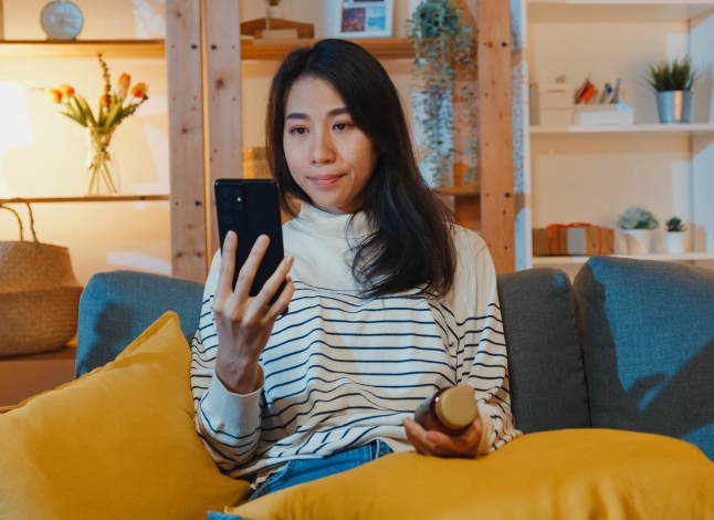 Woman looking at mobile device while sitting.